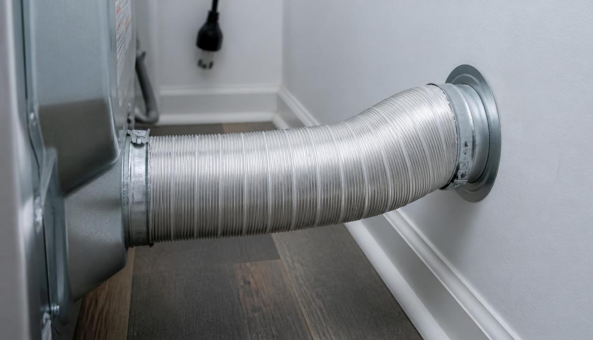 Code-compliant semi-rigid aluminium dryer transition duct newly installed between a dryer and the wall vent.