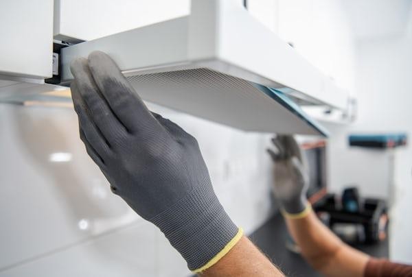 A professional evaluating an air duct in California and offering cleaning services